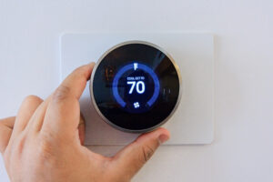 Hand,adjusting,air,conditioner,button,at,70,degree,fahrenheit,in